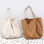 Two large canvas women handbags in beige and brown with soft handles suitable for shopping and daily use