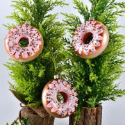 Pink donut-shaped glass Christmas decorations pendant hanging on green pine branches