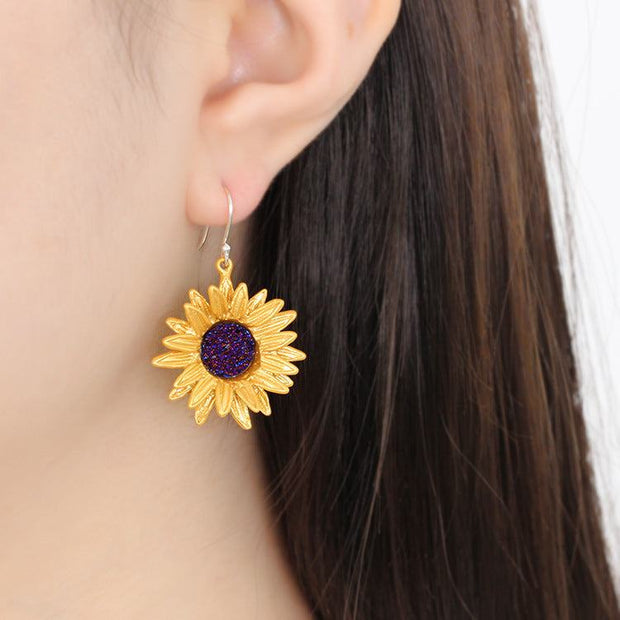 Close-up of Niche Sunflower Ear Hook gold plated copper earrings worn on ear