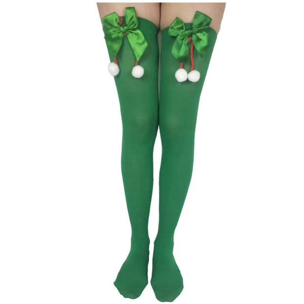Green polyester Christmas stockings with festive bows and white pom-poms, knee-high party socks
