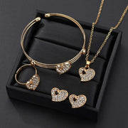 Gold love jewelry set with heart-shaped crystal earrings, ring, necklace, and bracelet in black box