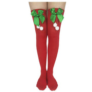 Red Christmas stockings with green satin bows and white pom-poms, party accessory socks
