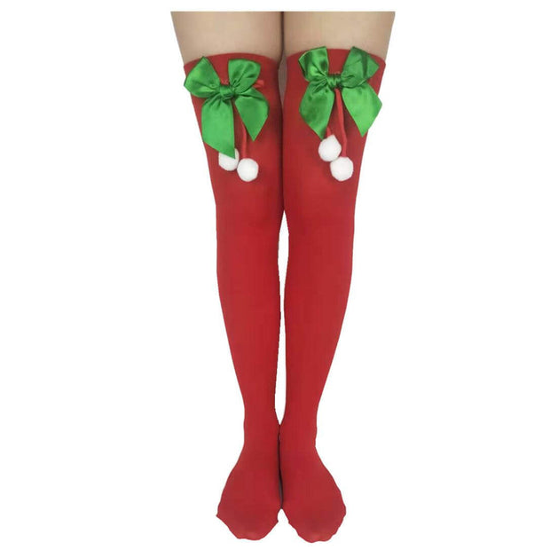Red Christmas stockings with green satin bows and white pom-poms, party accessory socks