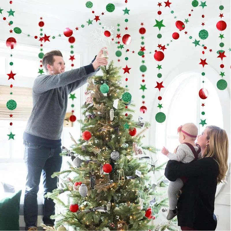 Christmas decorations for home with red and green hanging paper star and dot garland around decorated Christmas tree