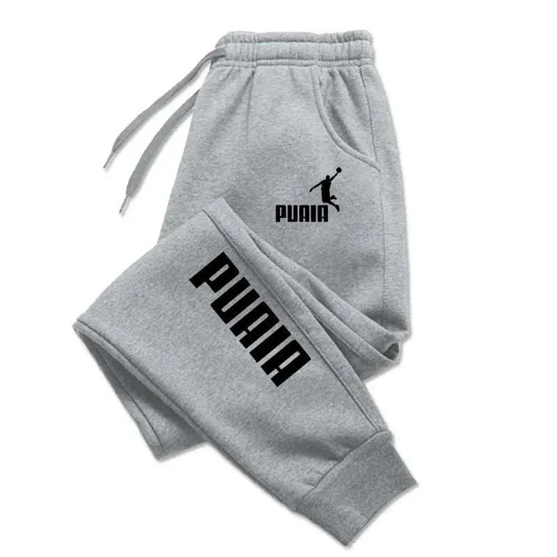 Grey men's print pants with black PUMA logo, drawstring waist, ankle-length, casual fitness joggers