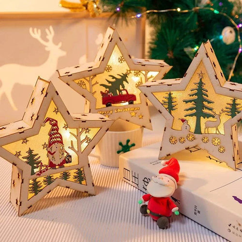 Luminous wooden star-shaped Christmas decorations with festive cutouts and warm light, placed near a Santa figurine and Christmas tree.