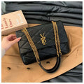 Stylish black quilted leather ladies' bag with gold chain crossbody strap and VBL logo on brown coat background