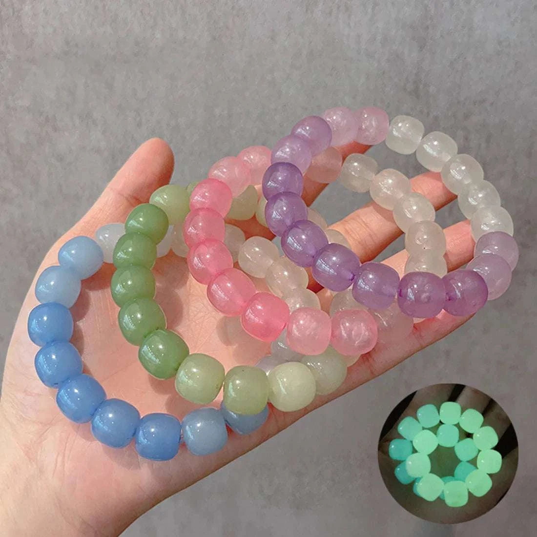 Colorful luminous stone bracelets made of round plastic beads, glowing in the dark, elastic stretch wristbands for women and kids.