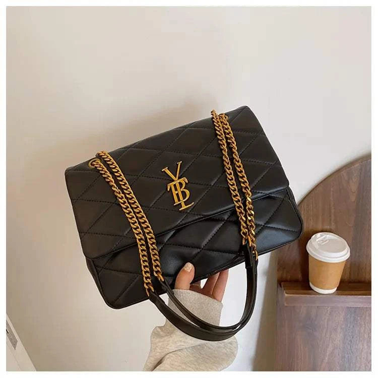 Stylish black leather ladies' bag with gold chain crossbody strap and quilted design