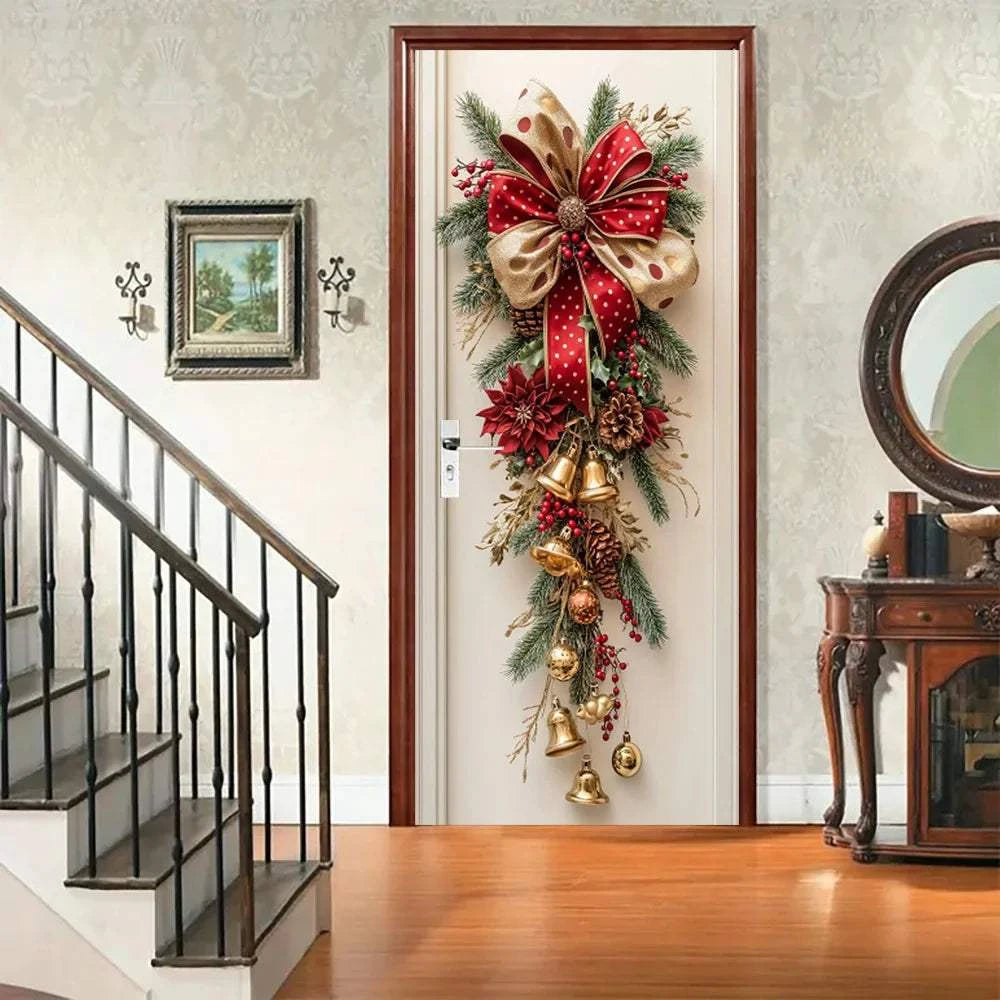 Christmas wall decoration with red bells, green leaves, pinecones, and a large red and gold bow hanging on a door
