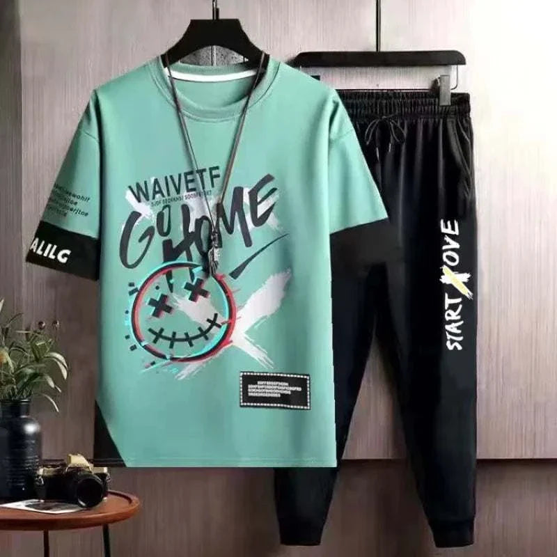 Men's casual tracksuit set with printed green O-neck T-shirt and black elastic jogging pants with drawstring closure.