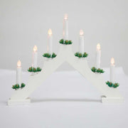 White wooden Christmas window decoration candlesticks with LED lights and green accents