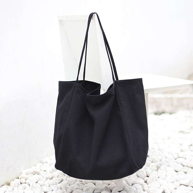 Large black canvas women handbag with high capacity and shoulder straps for shopping and daily use