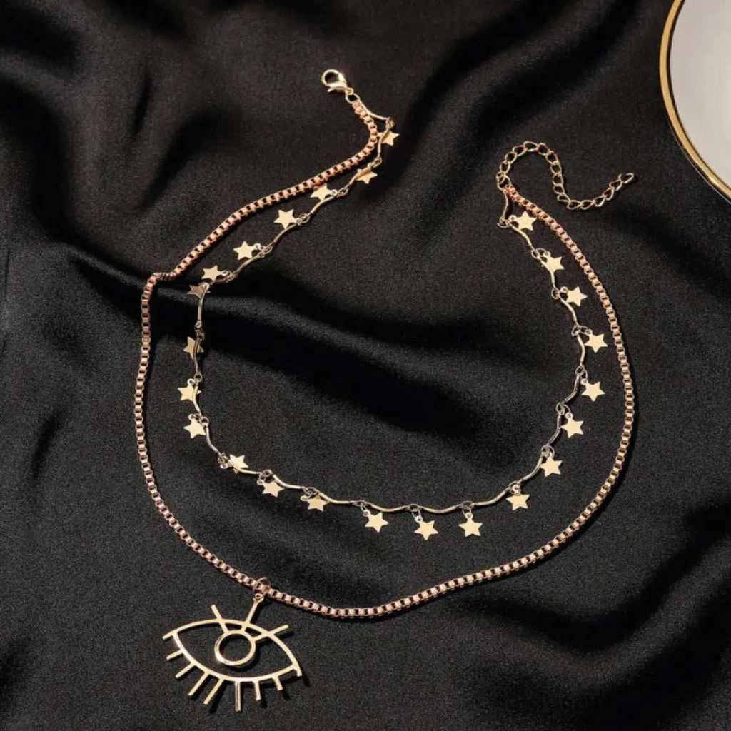 Emme Necklace - Dazzling Double Strand with Evil Eye displayed on a dark background featuring star droplets and an evil eye pendant.