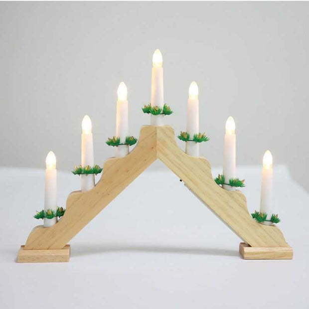 Wooden Christmas window decoration with white LED candlesticks and green accents