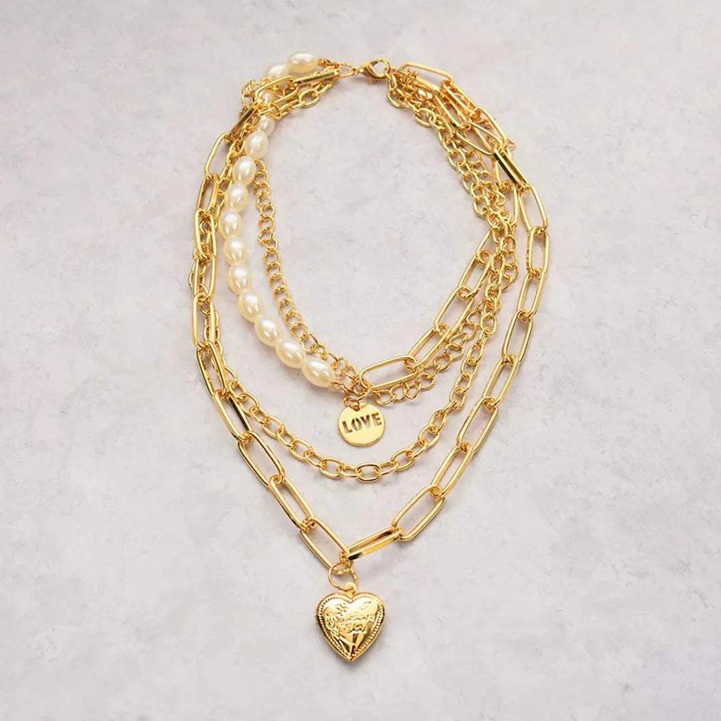 Jester Necklace featuring layered gold chains, pearls, and a heart pendant with 'LOVE' engraving.
